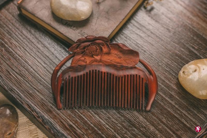 (左)精雕细琢的梳子“荷塘夜色”。(下)谭木匠镶齿梳:莲语。 (图片由谭木匠提供) (左)精雕细琢的梳子“荷塘夜色”。(下)谭木匠镶齿梳:莲语。 (图片由谭木匠提供)