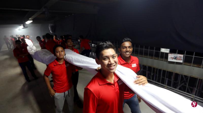 今年国庆庆典表演第四幕中出现的巨型国旗,约37公尺长、18公尺宽,重量达150公斤,需动员90人搬运到舞台上及摊开,呈现观众眼前。(严宣融摄) 今年国庆庆典表演第四幕中出现的巨型国旗,约37公尺长、18公尺宽,重量达150公斤,需动员90人搬运到舞台上及摊开,呈现观众眼前。(严宣融摄)