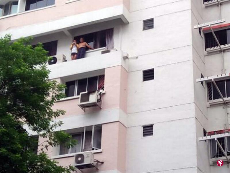 60来岁的阿叔和14岁养女昨午无法从门口逃出,爬出窗外站在窗沿等候救援。(受访者提供) 60来岁的阿叔和14岁养女昨午无法从门口逃出,爬出窗外站在窗沿等候救援。(受访者提供)