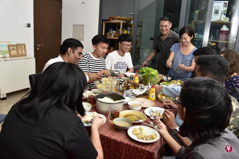 唐肯尼斯与妻子（站立者）全职为有需要的人提供栖身之所。上周聚会的与会者还包括借住他们家的人、几名义工和好友。（《海峡时报》）