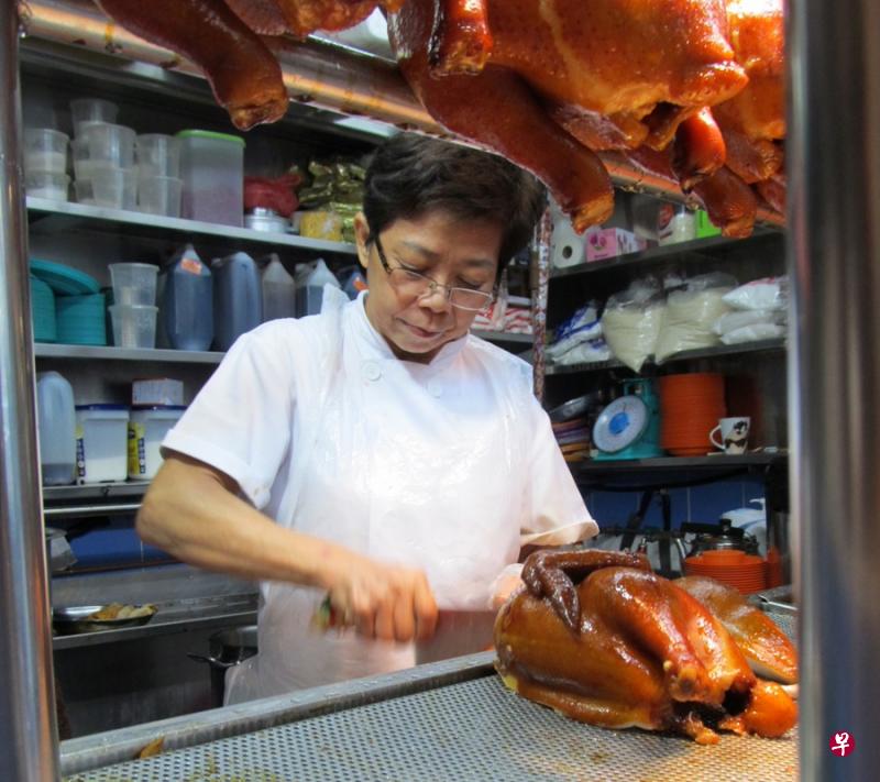 萧佩玲向父亲学习如何制作油鸡,从准备材料、烹煮到斩鸡肉,她凡事都亲力亲为。(档案照) 萧佩玲向父亲学习如何制作油鸡,从准备材料、烹煮到斩鸡肉,她凡事都亲力亲为。(档案照)