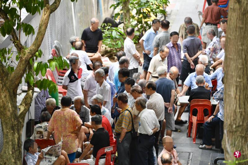 牛车水大厦旁的亭子聚集近百人,旁观者也可下注开赌。 牛车水大厦旁的亭子聚集近百人,旁观者也可下注开赌。