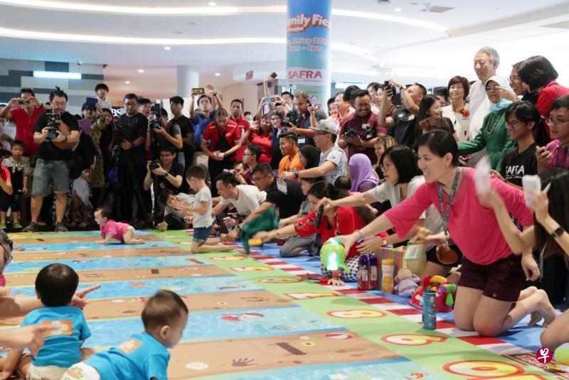 小宝宝爬行比快,家长也毫不轻松,除了大声鼓励喝彩,还得使尽法宝,以玩具、气球、零食及水壶等物品诱导孩子向前爬,场面逗趣可爱。图为哈莉玛总统(图右绿衣者)及在她右侧的副总理兼国家安全统筹部长张志贤,在现场观赛。(海峡时报) 小宝宝爬行比快,家长也毫不轻松,除了大声鼓励喝彩,还得使尽法宝,以玩具、气球、零食及水壶等物品诱导孩子向前爬,场面逗趣可爱。图为哈莉玛总统(图右绿衣者)及在她右侧的副总理兼国家安全统筹部长张志贤,在现场观赛。(海峡时报)