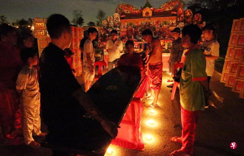 躺棺的妇女身穿黑衣黑裤,在丈夫和两个儿子与媳妇的陪伴下来到坟场。 躺棺的妇女身穿黑衣黑裤,在丈夫和两个儿子与媳妇的陪伴下来到坟场。
