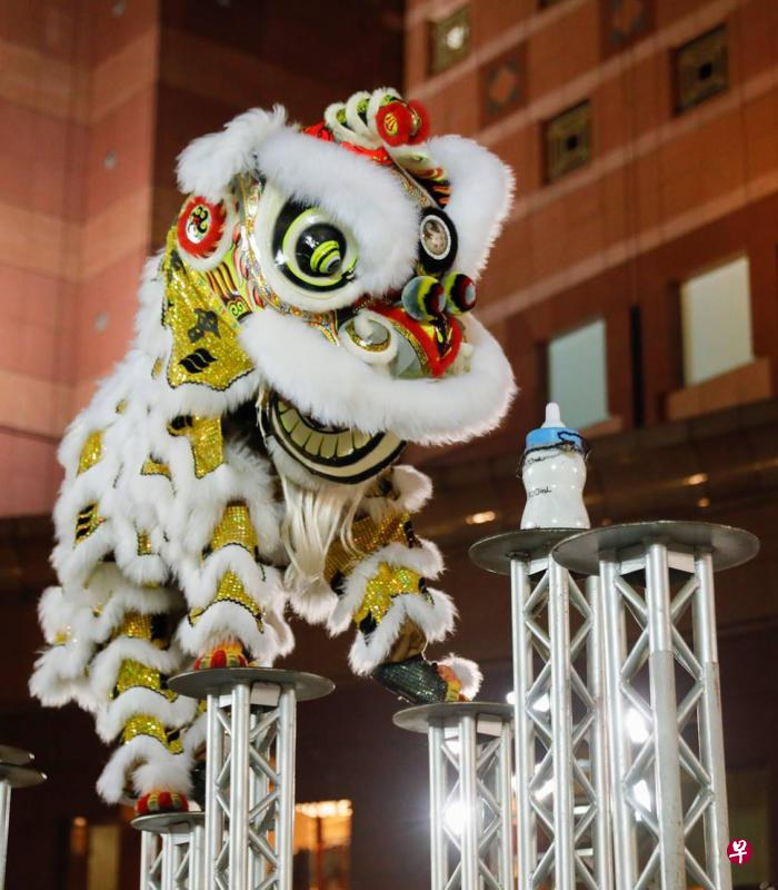 醒狮在高桩上准备拿起奶瓶。(取自面簿) 醒狮在高桩上准备拿起奶瓶。(取自面簿)