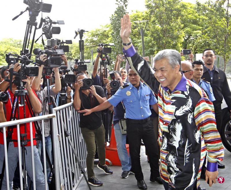 阿末扎希(右)抵达反贪会总部时笑容满面,多次向媒体记者挥手致意。(星洲日报) 阿末扎希(右)抵达反贪会总部时笑容满面,多次向媒体记者挥手致意。(星洲日报)