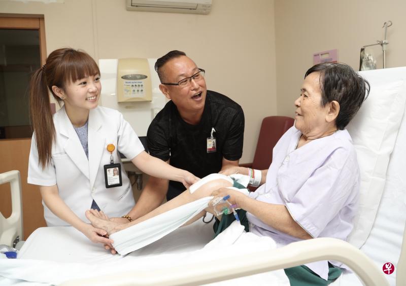 参与了陈笃生医院与淡马锡关怀基金会联合推出的义工计划,曾在医院做全膝关节置换手术的林添明(中)接受物理治疗师培训后,将定期到医院监督并协助做了相同手术的病患进行床上脚部运动。(王彦燕摄) 参与了陈笃生医院与淡马锡关怀基金会联合推出的义工计划,曾在医院做全膝关节置换手术的林添明(中)接受物理治疗师培训后,将定期到医院监督并协助做了相同手术的病患进行床上脚部运动。(王彦燕摄)