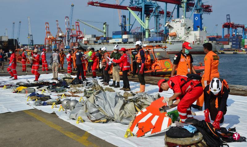 在雅加达的丹戎不碌,搜救队将捞起的机身与机内物件的碎片一一排在码头,包括印有狮航红色标志的部分机尾。(路透社) 在雅加达的丹戎不碌,搜救队将捞起的机身与机内物件的碎片一一排在码头,包括印有狮航红色标志的部分机尾。(路透社)