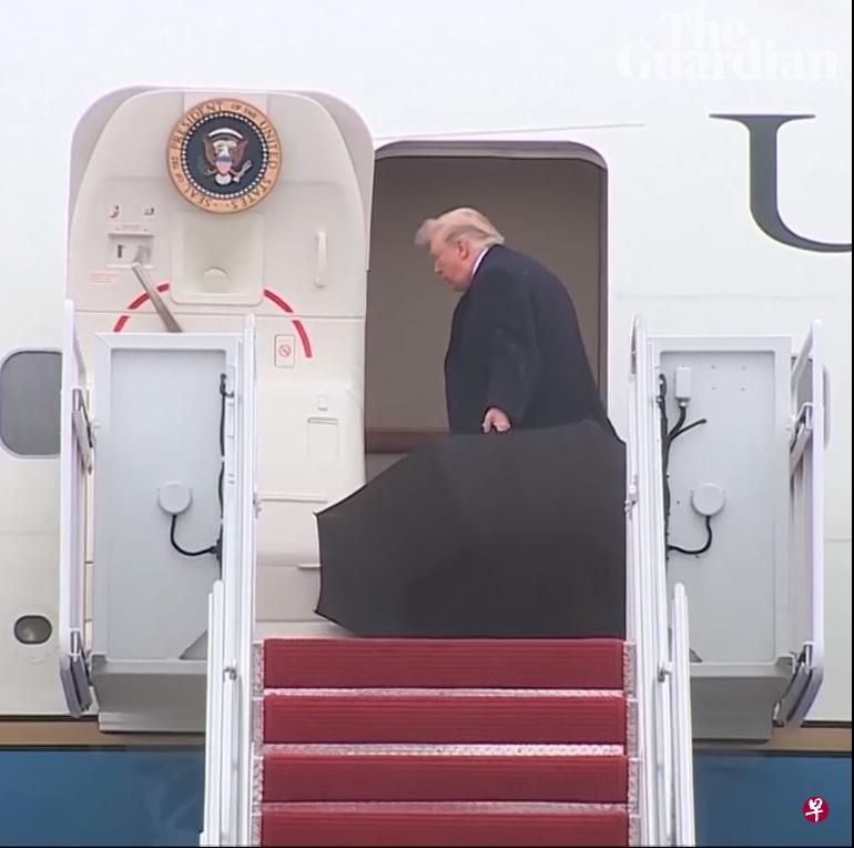 特朗普把黑色大雨伞丢在机舱门外,任由雨伞在风雨中翻滚。 特朗普把黑色大雨伞丢在机舱门外,任由雨伞在风雨中翻滚。