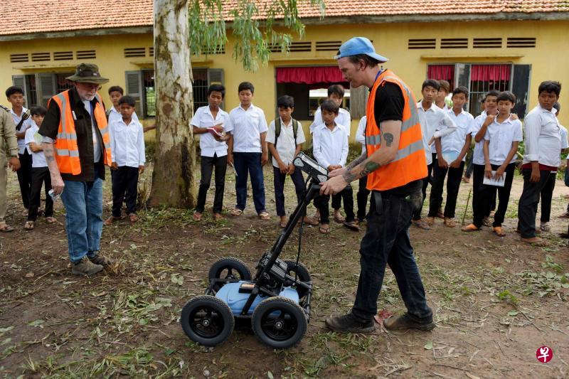 一家探测公司的员工推动一个像割草机的雷达探测器来寻找乱葬岗。(法新社) 一家探测公司的员工推动一个像割草机的雷达探测器来寻找乱葬岗。(法新社)