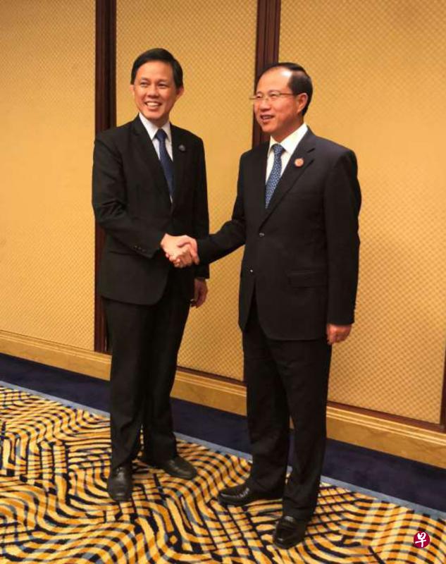 新加坡贸工部长陈振声（左）与中国商务部副部长傅自应在首届中国进博会的场边会面并举行会谈。（贸工部提供）　