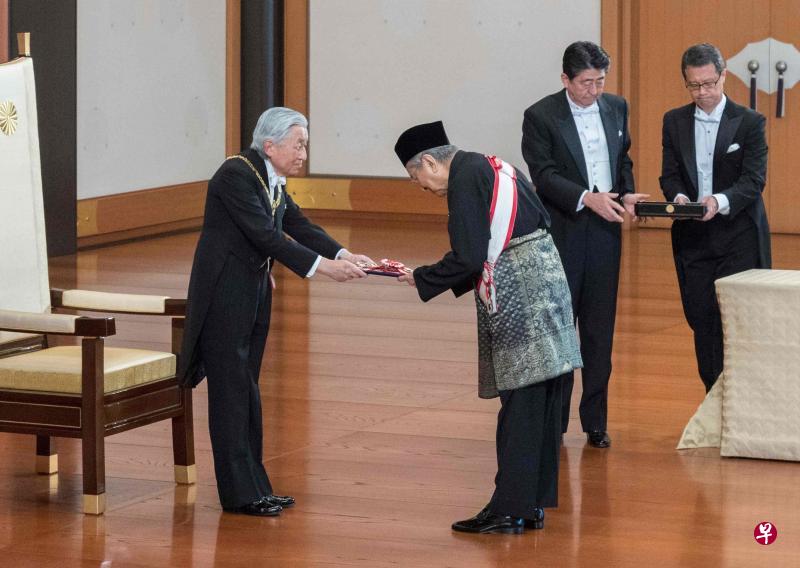 日本明仁天皇(左一)周二上午在皇宫颁授“一等桐花大绶章”给马来西亚首相马哈迪(左二)。右二为日本首相安倍晋三。(法新社) 日本明仁天皇(左一)周二上午在皇宫颁授“一等桐花大绶章”给马来西亚首相马哈迪(左二)。右二为日本首相安倍晋三。(法新社)