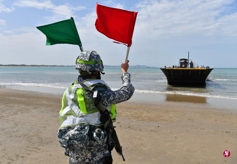 由海陆两军组成的“海滩备用特遣队”负责把选定的海滩,设成军方接引兵源和物资的专用着落点。图为海军海滩单位人员在引导军用快艇停靠海岸。(海峡时报) 由海陆两军组成的“海滩备用特遣队”负责把选定的海滩,设成军方接引兵源和物资的专用着落点。图为海军海滩单位人员在引导军用快艇停靠海岸。(海峡时报)