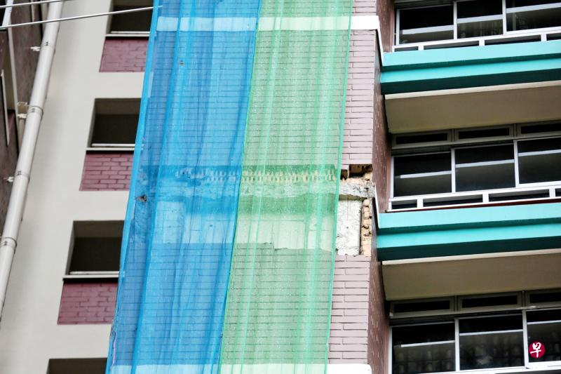 组屋外墙红砖剥落后,市镇会马上封锁现场,并用巨网罩住缺口,确保砖块不会砸到人。(徐颖荃摄) 组屋外墙红砖剥落后,市镇会马上封锁现场,并用巨网罩住缺口,确保砖块不会砸到人。(徐颖荃摄)