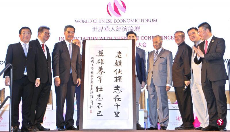 马哈迪(右四)周五在“世界华人经济论坛”上获赠马来西亚书法名家的墨宝,写着:“老骥伏枥志在千里,英雄暮年壮志不已”。左二为香港前特首梁振英。(星洲日报) 马哈迪(右四)周五在“世界华人经济论坛”上获赠马来西亚书法名家的墨宝,写着:“老骥伏枥志在千里,英雄暮年壮志不已”。左二为香港前特首梁振英。(星洲日报)