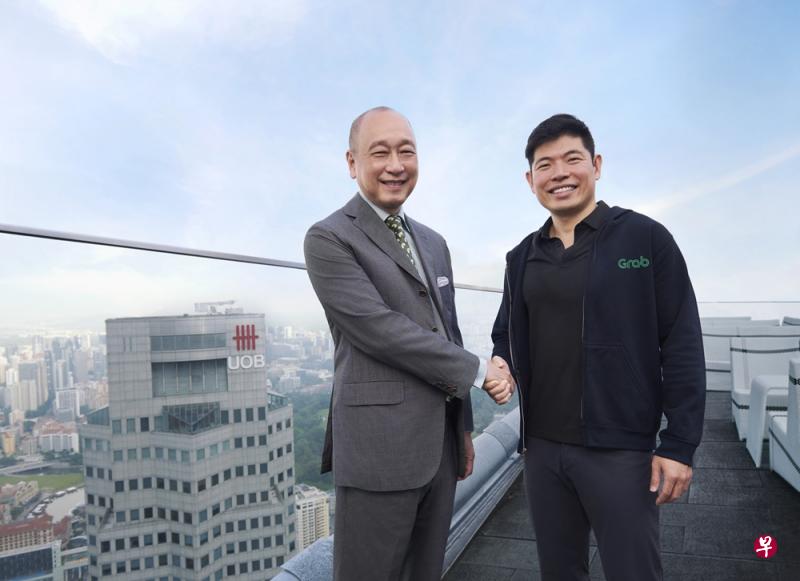大华银行副主席兼总裁黄一宗(左)和Grab首席执行官陈炳耀握手宣布成立合作伙伴关系。(大华银行提供) 大华银行副主席兼总裁黄一宗(左)和Grab首席执行官陈炳耀握手宣布成立合作伙伴关系。(大华银行提供)
