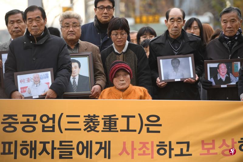 日本强征韩国劳工案受害人金圣珠(前排中)和其他受害人的亲属到法庭听审。(法新社) 日本强征韩国劳工案受害人金圣珠(前排中)和其他受害人的亲属到法庭听审。(法新社)