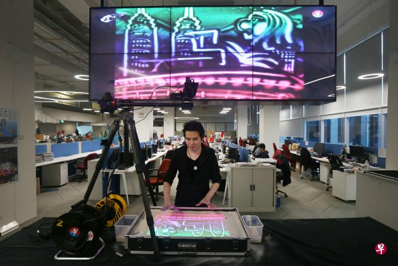 本地沙画家许凌福(Lawrence Koh,33岁)在新闻中心的新闻室内现场表演沙画艺术,揭晓今年的年度汉字——“马”。(梁伟康摄) 本地沙画家许凌福(Lawrence Koh,33岁)在新闻中心的新闻室内现场表演沙画艺术,揭晓今年的年度汉字——“马”。(梁伟康摄)