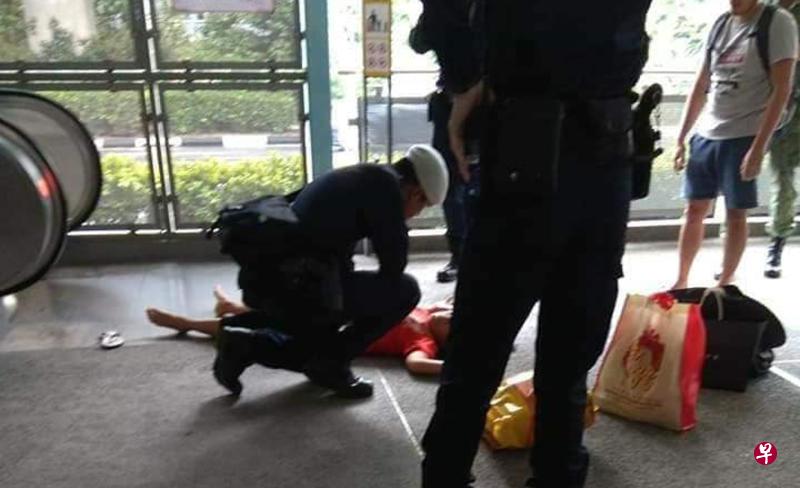 女佣跌倒后,公共交通保安指挥处人员上前查看。(取自网络) 女佣跌倒后,公共交通保安指挥处人员上前查看。(取自网络)