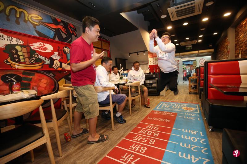 牛车水登婆街一家火锅店推出小游戏,让顾客以立定跳远来决定可获得多少餐费折扣。(邝启聪摄) 牛车水登婆街一家火锅店推出小游戏,让顾客以立定跳远来决定可获得多少餐费折扣。(邝启聪摄)