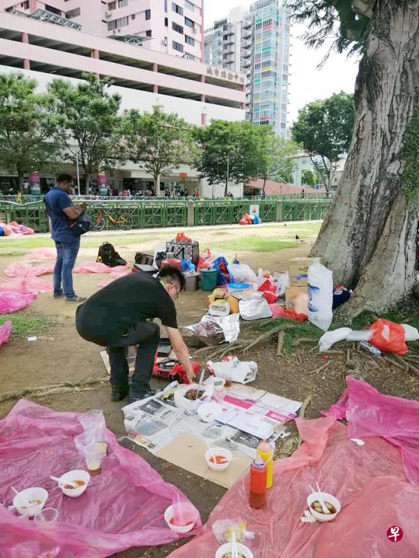 一名执法人员弯腰查看摆在地上的食物。(取自网络) 一名执法人员弯腰查看摆在地上的食物。(取自网络)