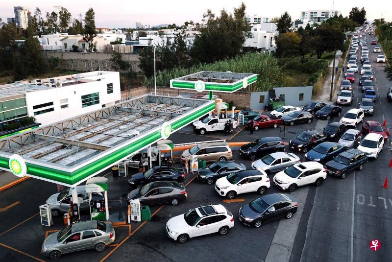 在墨西哥哈利斯科州的萨波潘,许多添油站因燃油短缺索性停业,导致继续营业的油站出现长长的车龙。(法新社) 在墨西哥哈利斯科州的萨波潘,许多添油站因燃油短缺索性停业,导致继续营业的油站出现长长的车龙。(法新社)