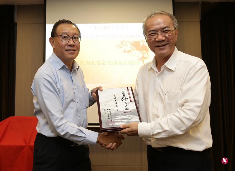 新加坡海南会馆会长潘家海(右)赠送《走过30年之旅》纪念刊给为中华文史课程服务了30年的符传丰讲师。(陈渊庄摄) 新加坡海南会馆会长潘家海(右)赠送《走过30年之旅》纪念刊给为中华文史课程服务了30年的符传丰讲师。(陈渊庄摄)