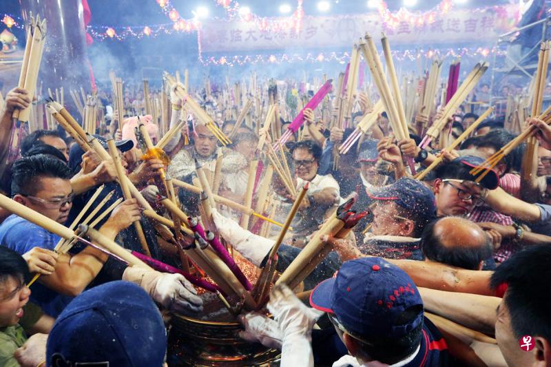 午夜一到,工作人员高喊一声“新年快乐”,众香客听到口令后,争先恐后把香插进香炉。(庄耿闻摄) 午夜一到,工作人员高喊一声“新年快乐”,众香客听到口令后,争先恐后把香插进香炉。(庄耿闻摄)