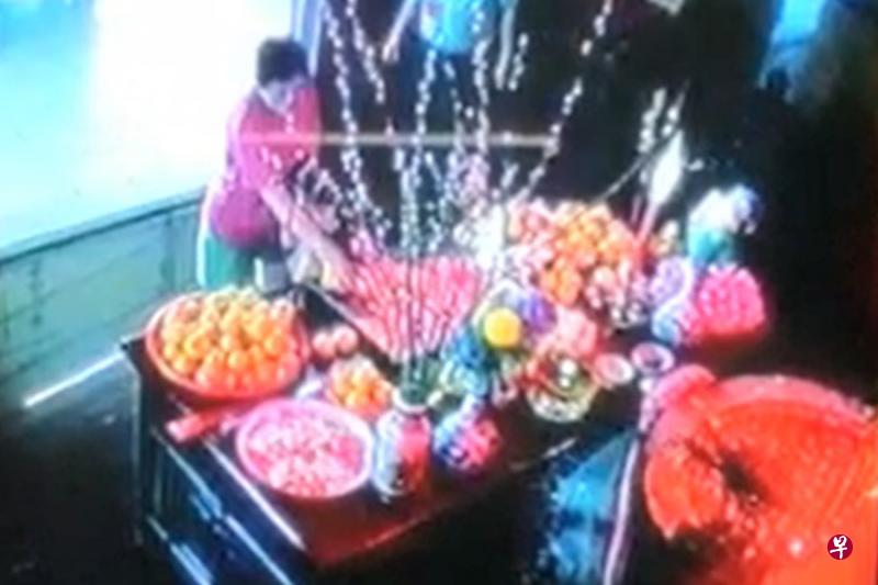 红衣嫂之后拿着一个小袋子,再次出现在庙宇内,一把抓起多封红包塞入袋中。(受访者提供) 红衣嫂之后拿着一个小袋子,再次出现在庙宇内,一把抓起多封红包塞入袋中。(受访者提供)