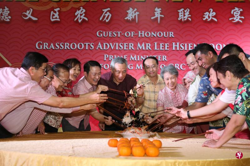 李显龙总理(左六)和夫人何晶(左八)昨晚出席宏茂桥德义区新春联欢晚宴,与2500多名居民捞鱼生。义顺集选区议员李美花(左四起)、交通部兼卫生部高级政务部长蓝彬明医生、德义区农历新年联欢宴会主席黄明辉、宏茂桥集选区议员殷丹博士、贸工部高级政务部长许宝琨医生、宏茂桥集选区议员杰乐·大卫等一同在台上捞鱼生。(谢智扬摄) 李显龙总理(左六)和夫人何晶(左八)昨晚出席宏茂桥德义区新春联欢晚宴,与2500多名居民捞鱼生。义顺集选区议员李美花(左四起)、交通部兼卫生部高级政务部长蓝彬明医生、德义区农历新年联欢宴会主席黄明辉、宏茂桥集选区议员殷丹博士、贸工部高级政务部长许宝琨医生、宏茂桥集选区议员杰乐·大卫等一同在台上捞鱼生。(谢智扬摄)
