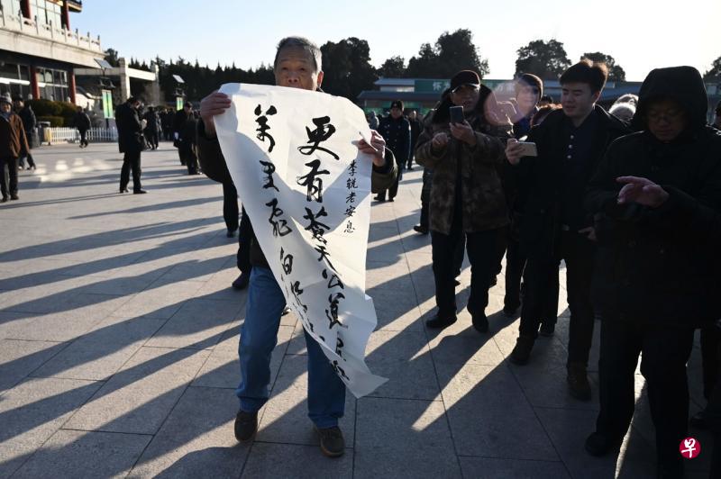 不少民众昨天到八宝山殡仪馆参加李锐的遗体告别仪式,一名民众在殡仪馆外出示悼念李锐的条幅。(法新社) 不少民众昨天到八宝山殡仪馆参加李锐的遗体告别仪式,一名民众在殡仪馆外出示悼念李锐的条幅。(法新社)
