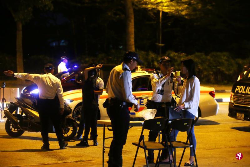 内政部将检讨违反交通规则，如酒驾导致他人死亡的刑罚。图为交警在1月4日晚上在共和国林荫道展开的酒驾取缔行动，一名司机在临检站接受酒测。（陈斌勤摄）