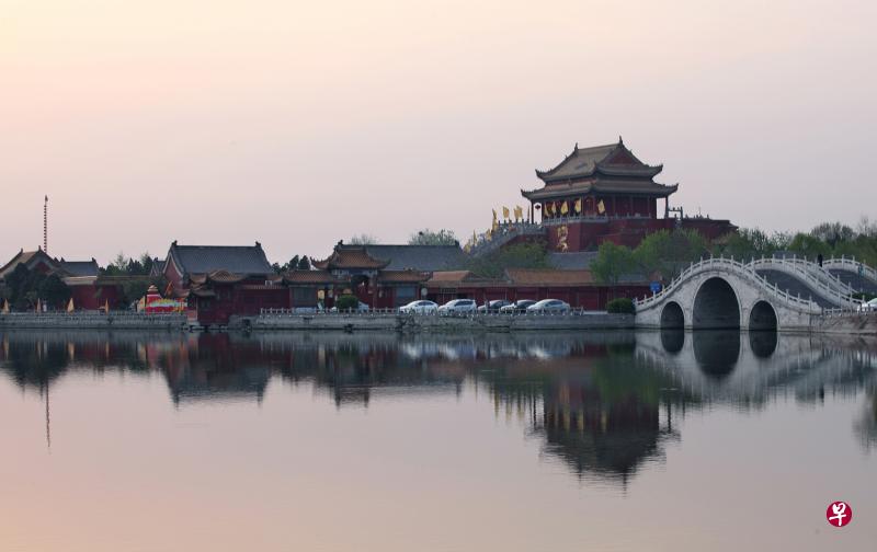 夕阳下的龙亭湖，宁谧独秀，拱桥、楼阁与湖中倒影相映成画。（王远昌摄）
