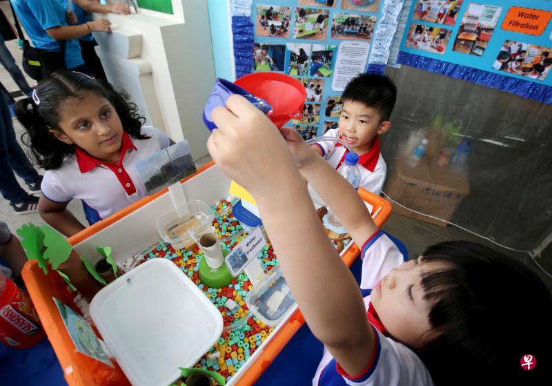 李德伦(中)跟同学蔡瑞芳(右)和妮拉昨天在滨海堤坝,利用模型向公众讲解水如何从蓄水池输送到住家。(严宣融摄) 李德伦(中)跟同学蔡瑞芳(右)和妮拉昨天在滨海堤坝,利用模型向公众讲解水如何从蓄水池输送到住家。(严宣融摄)