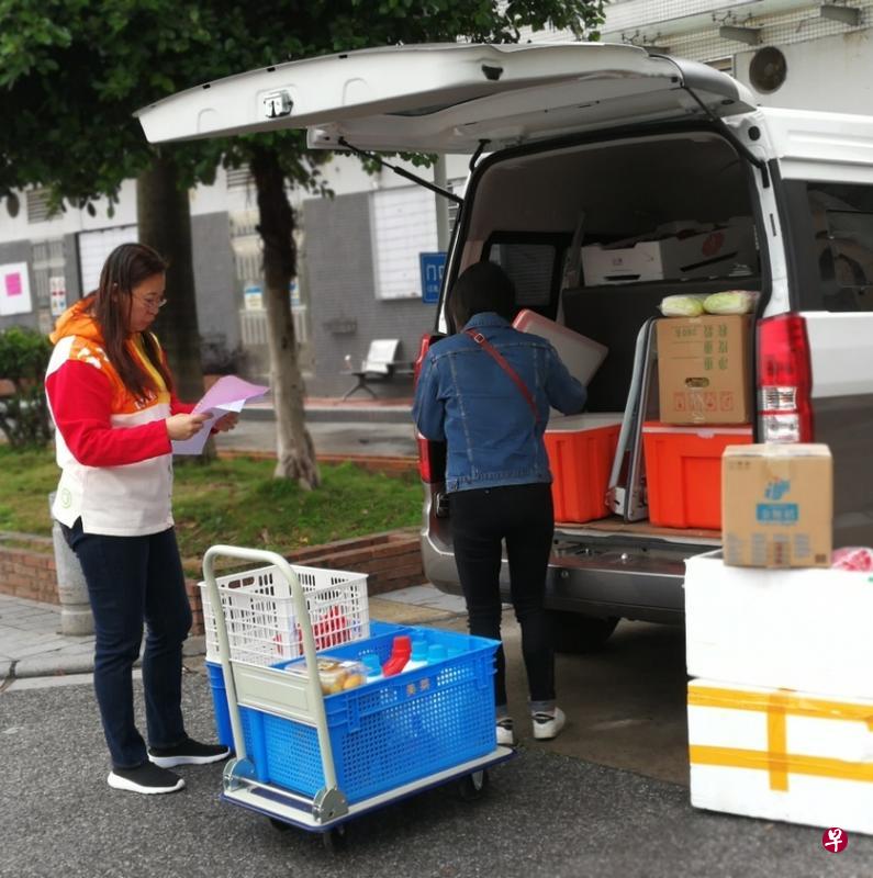 广州某小区社区团购的团长正在卸货。(曾实摄) 广州某小区社区团购的团长正在卸货。(曾实摄)