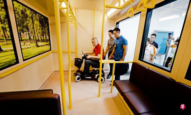 李显龙总理昨天参观盛港综合医院的复健中心时,乘坐电动轮椅,体验病人如何使用这类轮椅上下模拟巴士。(潘丰源摄) 李显龙总理昨天参观盛港综合医院的复健中心时,乘坐电动轮椅,体验病人如何使用这类轮椅上下模拟巴士。(潘丰源摄)