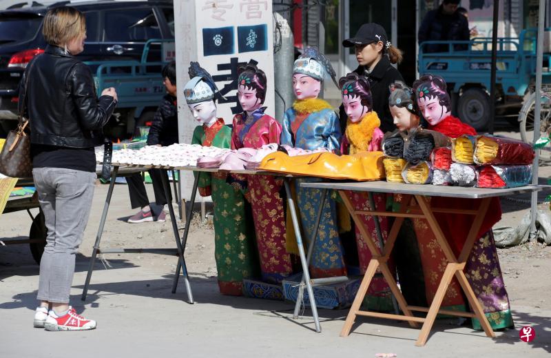 图为一名女顾客在当地俗称“鬼街”的批发市场上,向一名销售员询问价钱。(路透社) 图为一名女顾客在当地俗称“鬼街”的批发市场上,向一名销售员询问价钱。(路透社)