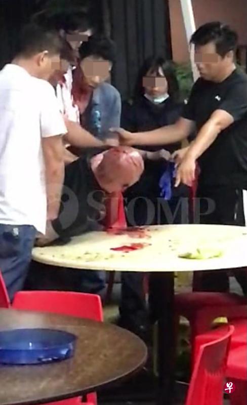 光头汉被几名男子制伏在桌上,民防人员到场。(取自STOMP) 光头汉被几名男子制伏在桌上,民防人员到场。(取自STOMP)