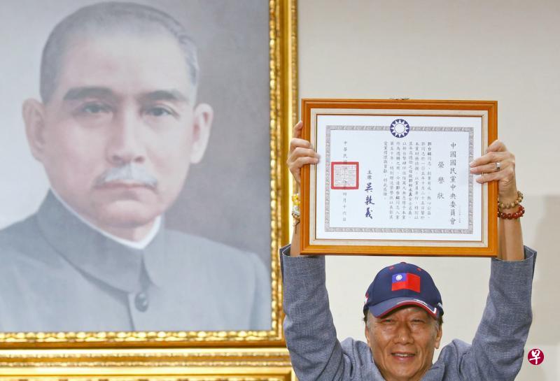 郭台铭高举国民党颁发给他的荣誉状,宣布将参加台湾2020年总统大选国民党党内初选。(路透社) 郭台铭高举国民党颁发给他的荣誉状,宣布将参加台湾2020年总统大选国民党党内初选。(路透社)
