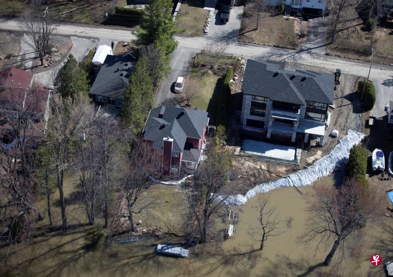 在魁北克省的拉瓦勒区,一些居民事先做好准备,在地势较低一方堆放沙包,暂时顶住大水的侵犯。(路透社) 在魁北克省的拉瓦勒区,一些居民事先做好准备,在地势较低一方堆放沙包,暂时顶住大水的侵犯。(路透社)