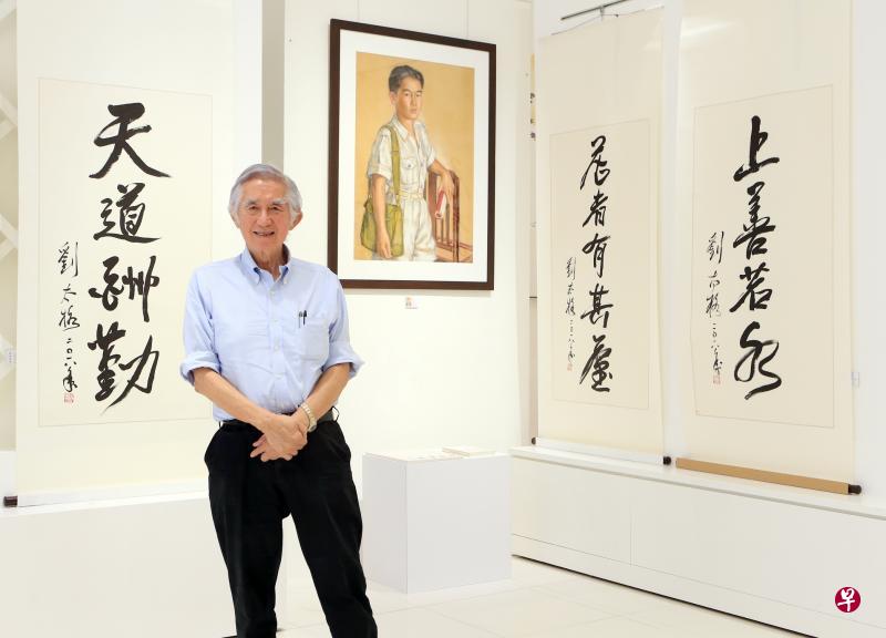 城市规划师、建筑师刘太格在父亲刘抗画12岁的自己的肖像粉画前留影。他的书法作品也第一次展出。（唐家鸿摄影）