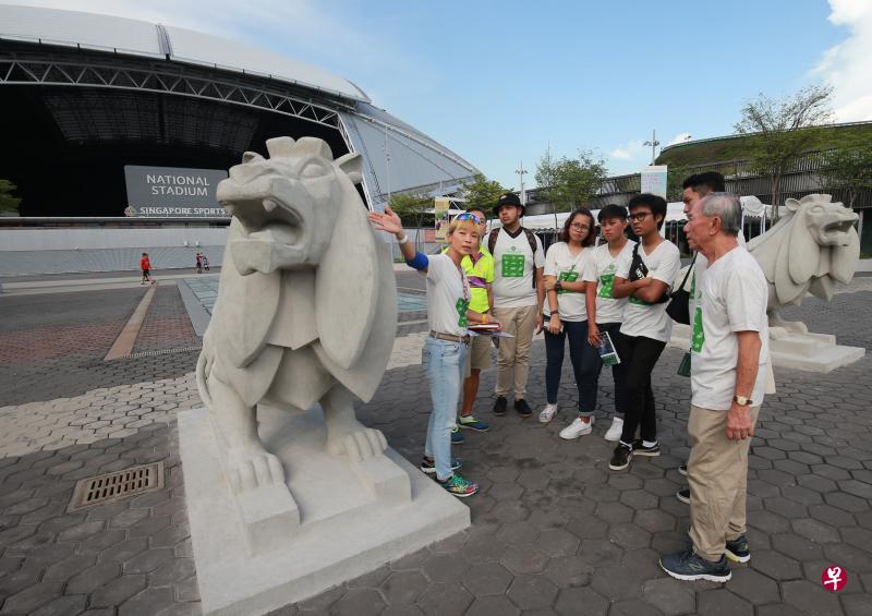 共和理工学院高级讲师张海燕（左一）是“加冷的故事——体育、艺术及文化遗产之旅”义务导览员，她昨天为公众介绍“默迪卡雄狮”的历史。（唐家鸿摄）