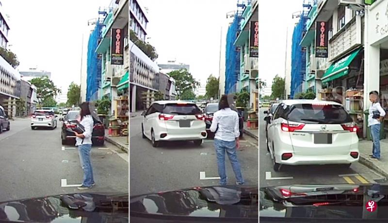 女郎不断向白色轿车挥手示意他停在该停车格内。(取自STOMP) 女郎不断向白色轿车挥手示意他停在该停车格内。(取自STOMP)