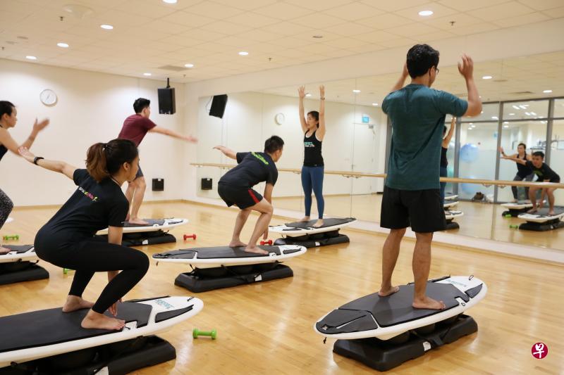 男女学员同做无水的“冲浪”运动Surfset,努力在冲浪板上平衡身体。 男女学员同做无水的“冲浪”运动Surfset,努力在冲浪板上平衡身体。