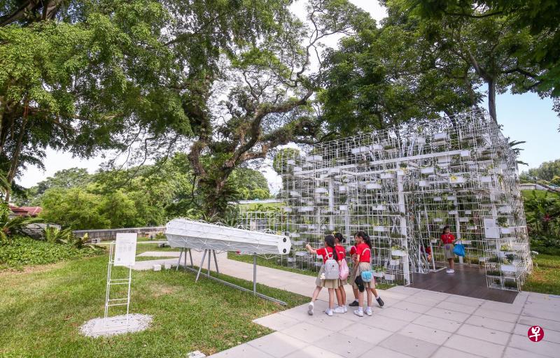 福康宁中心对面的小山头就是户外展览“历史寻踪”。三个巨型“望远镜”构成了名为“远眺”(Lookout)的装置,参观者可以欣赏到不同时期新加坡港口的风光;背景中的展厅“种子库”(Seed Conservatory)则展示了多种本地原生植物以及被引进本地的经济作物种子。(陈斌勤摄) 福康宁中心对面的小山头就是户外展览“历史寻踪”。三个巨型“望远镜”构成了名为“远眺”(Lookout)的装置,参观者可以欣赏到不同时期新加坡港口的风光;背景中的展厅“种子库”(Seed Conservatory)则展示了多种本地原生植物以及被引进本地的经济作物种子。(陈斌勤摄)