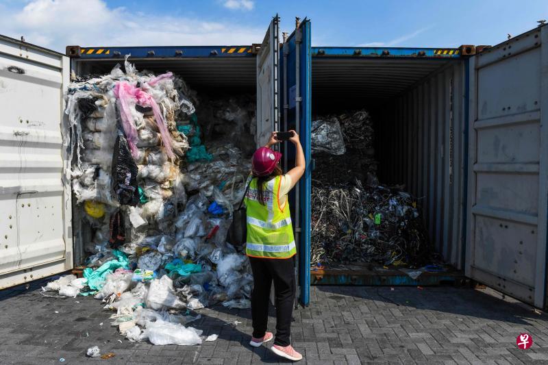 马来西亚政府周二宣布将送回60个非法进口的洋垃圾货柜。图为一名记者正在拍摄满货柜的洋垃圾。（法新社）