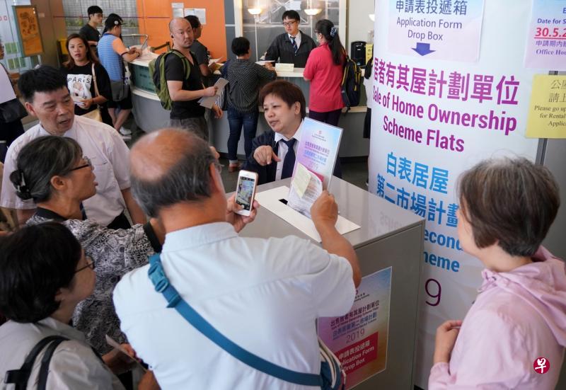 众多香港市民昨早到房屋委员会客务中心提交居屋申请表,一名申请者更用手机拍下自己交表瞬间,显现对这场“大抽奖”的期待。(中新社) 众多香港市民昨早到房屋委员会客务中心提交居屋申请表,一名申请者更用手机拍下自己交表瞬间,显现对这场“大抽奖”的期待。(中新社)