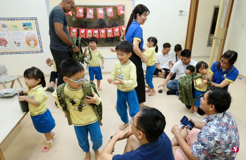 感谢国民服役人员的活动包括让孩童通过游戏、听前国民服役人员故事与亲身体验,了解战备军人的任务与扮演的角色。图为育星幼儿园学生在父亲的注目下,积极试背装有行军用品的背包。(梁麒麟摄) 感谢国民服役人员的活动包括让孩童通过游戏、听前国民服役人员故事与亲身体验,了解战备军人的任务与扮演的角色。图为育星幼儿园学生在父亲的注目下,积极试背装有行军用品的背包。(梁麒麟摄)