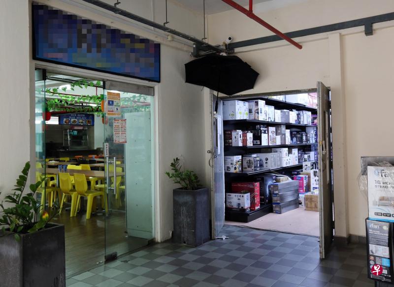 黑色雨伞就高高挂在女老板的大门上,遮住电眼的镜头。(庄耿闻摄影) 黑色雨伞就高高挂在女老板的大门上,遮住电眼的镜头。(庄耿闻摄影)