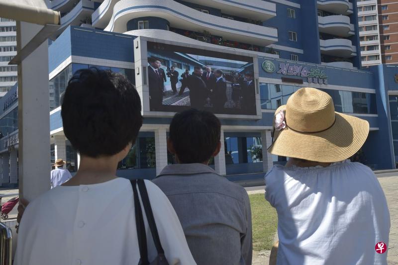 7月1日当天,一些朝鲜市民通过大型电子屏幕观看朝美领导人在板门店会晤的新闻报道。(法新社) 7月1日当天,一些朝鲜市民通过大型电子屏幕观看朝美领导人在板门店会晤的新闻报道。(法新社)